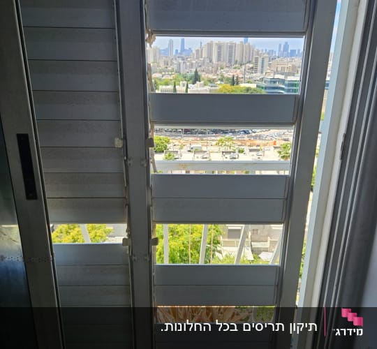 תריס גלילה פתוח עם נוף עירוני ברקע